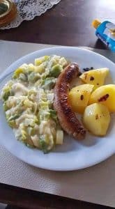 Bratwurst mit Lauchgemüse und neuen Kartoffeln in Röstfett