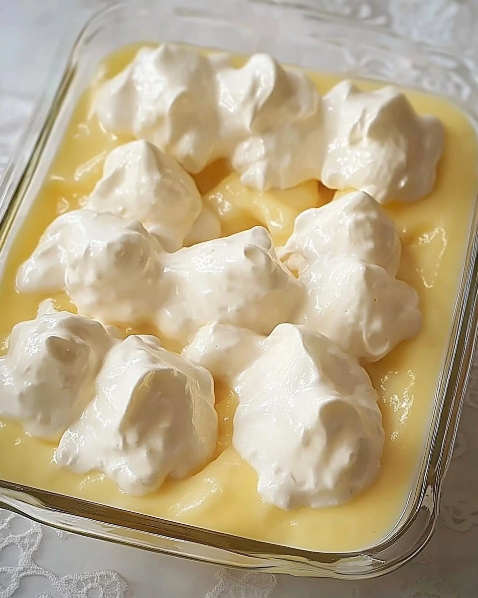 Schneenockerl serviert in cremiger Vanillesauce