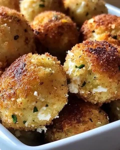 Knusprige Zucchini-Feta-Bällchen auf einem Teller serviert