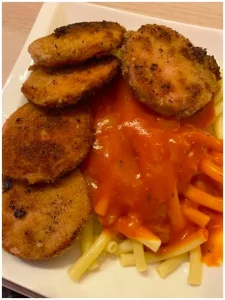 DDR Makkaroni mit Tomatensoße und knusprigem Jägerschnitzel auf einem Teller