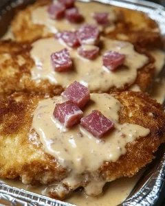 Elsässischer Schnitzel überbacken mit Zwiebeln und Speck auf einem Teller