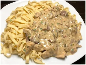 Geschnetzeltes mit Bandnudeln auf einem Teller serviert