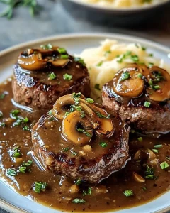 Hacksteaks mit Pilz-Zwiebel-Sauce auf einem Teller angerichtet