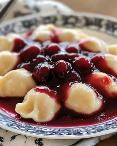 Mehlklöße mit Kirschsoße serviert auf einem Teller