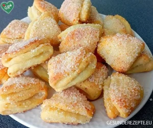 Leckere Quark-Dreiecke auf einem Teller serviert mit einer Tasse Kaffee.