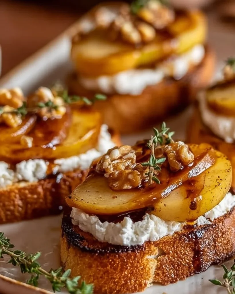 Karamellisierte Birnen auf Ziegenkäse-Crostini, serviert auf einem eleganten Teller.