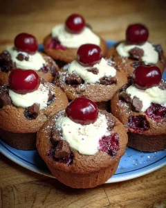 Schwarzwälder Kirsch-Muffins mit Schokolade und Kirschen auf einem Teller