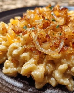 Ein Teller mit frisch zubereiteten Käsepätzle, garniert mit Käse und Zwiebeln.
