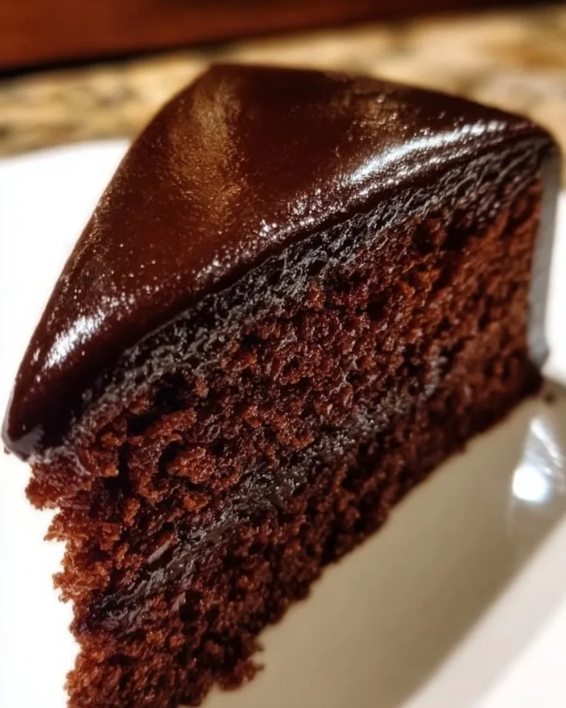 Perfekte Sachertorte mit Schokolade und Aprikosenmarmelade auf einem Teller