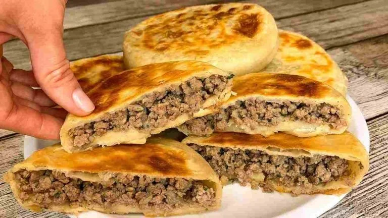 Fladen gefüllt mit Hackfleisch, frisch zubereitet und serviert auf einem Tisch.