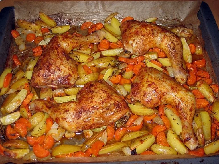 Hähnchenschenkel vom Blech, goldbraun gebacken und serviert mit Gemüse