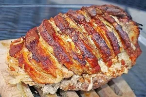 Leckeres Räuberbraten à la Mutti auf einem Teller serviert, umgeben von frischen Kräutern.