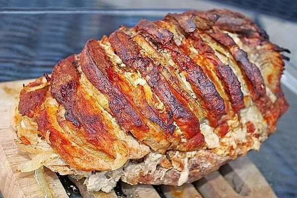 Leckeres Räuberbraten à la Mutti auf einem Teller serviert, umgeben von frischen Kräutern.