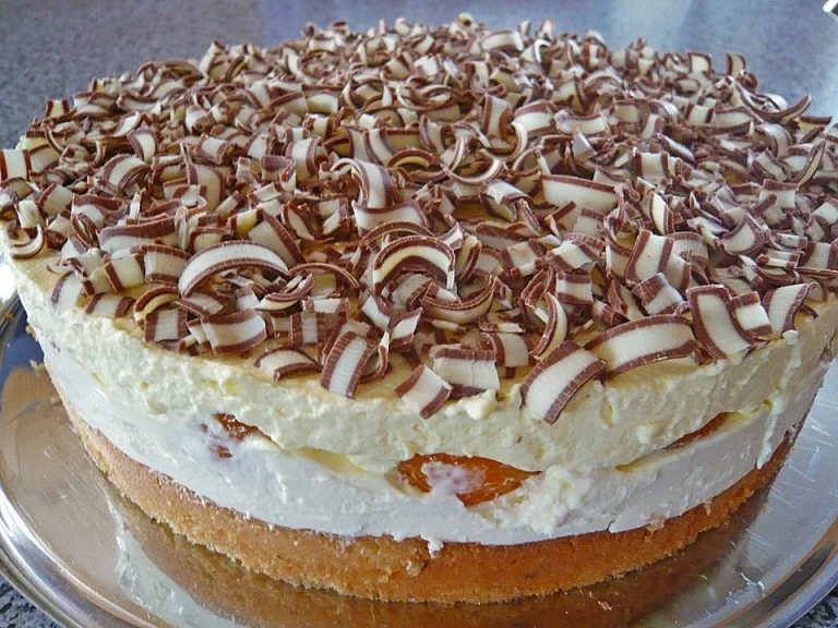 Ein Stück Rittersporttorte auf einem Teller, dekoriert mit Schokoladensplittern.