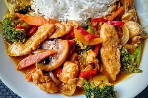 Schnelles Thai-Curry mit Huhn, Paprika und Erdnüssen auf einem Teller