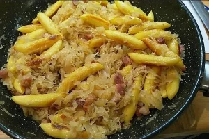 Hausgemachte Schupfnudeln mit Sauerkraut und knusprigen Speckwürfeln.