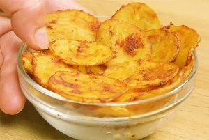 Selbstgemachte Kartoffelchips auf einem Holzbrett serviert