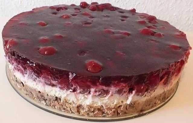 Schnitte einer Prinzenrolle-Torte auf einem Teller, dekoriert mit Schokolade und Sahne.