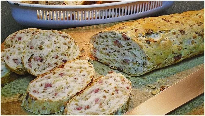 Zwiebel-Käse-Schinken-Brot frisch gebacken und serviert auf einem Holzbrett.